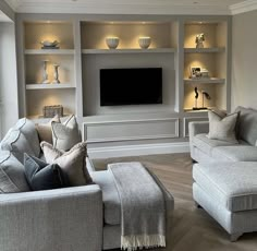 a living room filled with furniture and a flat screen tv mounted on a wall above it