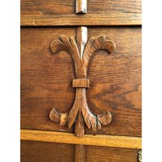 an ornate wooden door handle on the side of a wood paneled cabinet with metal handles