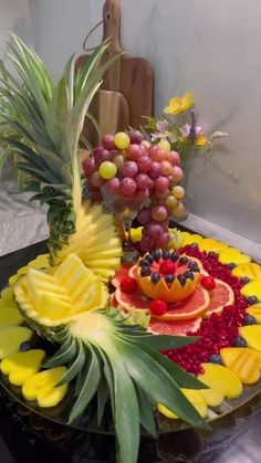 a fruit platter with pineapples, grapes, and watermelon on it