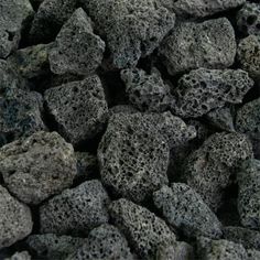 black rocks are piled together on the ground