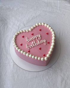 a heart shaped birthday cake with the words happy birthday written in frosting on it