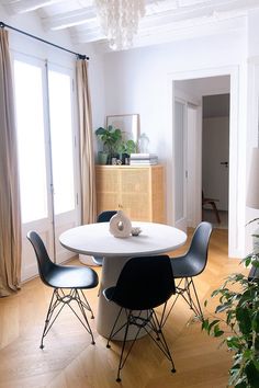 a white table with black chairs in a living room