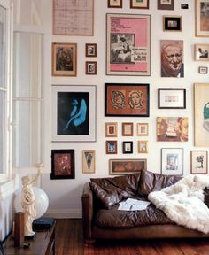 a living room filled with furniture and lots of pictures on the wall