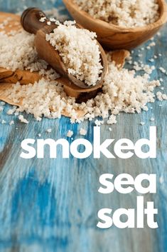 there are two wooden spoons with sea salt in them and the words smoked sea salt on it