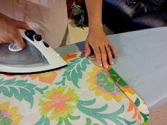 a woman ironing fabric with an electric iron