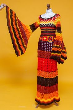 a crocheted dress is displayed on a mannequin's head stand