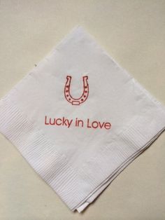 a napkin with the words lucky in love on it and a horseshoe drawn on it