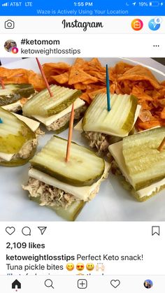 a white plate topped with pickles and carrots on top of a pile of chips