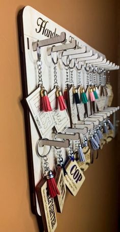 a wall mounted key holder with many different items hanging from it's hooks and keys