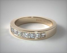 a gold wedding band with princess cut diamonds on the side and channel set in between