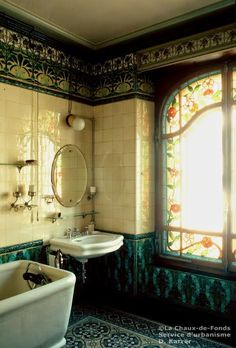 a bathroom with two sinks and a bathtub in front of a stained glass window