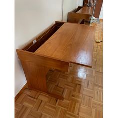 a wooden desk sitting on top of a hard wood floor in front of a mirror