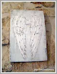 an angelic heart carved into a stone wall with white paint and black lines on it