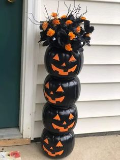 a stack of pumpkins with flowers in them