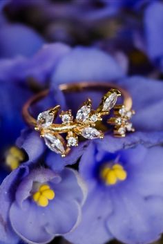 a close up view of a ring with flowers in the background