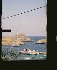 the view from inside a window looking at boats in the water