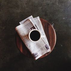 a cup of coffee sitting on top of a wooden plate