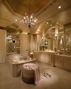 a fancy bathroom with chandelier, bathtub and candles on the countertop