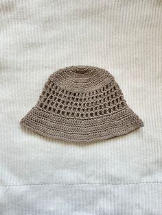 Protect yourself from the sun in style with this crocheted bucket hat with mesh-like details! This hat is made with 100% cotton yarn, so it is breathable and lightweight for warmer weather, and is washable. This listing is for an adult-sized hat in the color "taupe," more colors available in separate listings!  To clean, hand wash with cold water and lay flat to dry. Brimmed Crochet Hat In Cotton Yarn, Summer Cotton Yarn Hat, Summer Crochet Cotton Hat, Lightweight Summer Crochet Hat In Cream, Bohemian Lightweight Beige Crochet Hat, Adjustable Beige Crochet Hat, Brown Crochet Bucket Hat For The Beach, Beige Summer Crochet Hat, Summer Beige Crochet Sun Hat