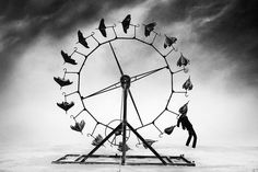 a ferris wheel with red flags flying in the sky