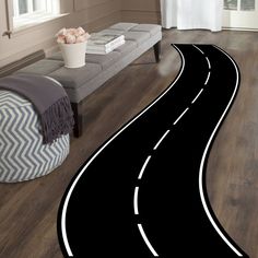 a black and white road rug in the middle of a living room with a couch