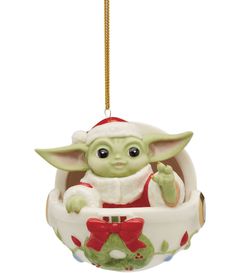 a christmas ornament with a baby yoda hanging from it's side