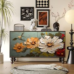 a living room with pictures on the wall and flowers painted on the sideboard in it