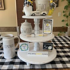 a three tiered tray with coffee cups and mugs on it that says lemonade