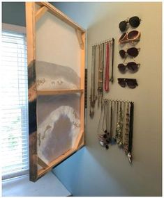 a wall mounted jewelry rack with sunglasses on it