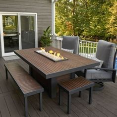 a table and chairs on a deck with a fire pit