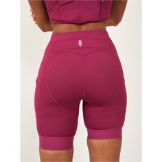 the back view of a woman's shorts with her hands on her hips, wearing pink