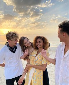 three people standing on the beach with one woman holding her hand out to another person