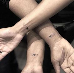 two people with matching tattoos on their hands