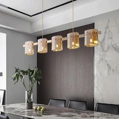 an elegant dining room with marble table and black leather chairs, gold chandelier