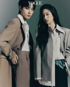 two people standing next to each other in front of a gray background with the words vogue written on it