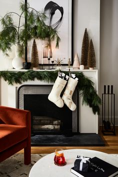 christmas stockings hanging from a fireplace mantel in front of a fire place with candles