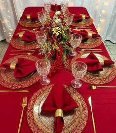 the table is set with red and gold place settings