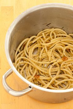 a pot filled with pasta sitting on top of a wooden table