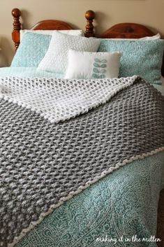 a crocheted blanket sitting on top of a bed next to two nightstands