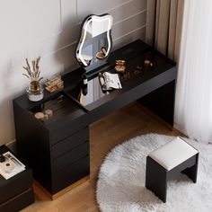 a desk with a mirror, stool and other items sitting on it in a room