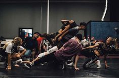 a group of people in a dance studio doing different moves on the floor with their hands together