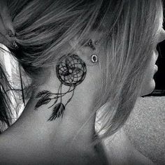 the back of a woman's neck with tattoos on it