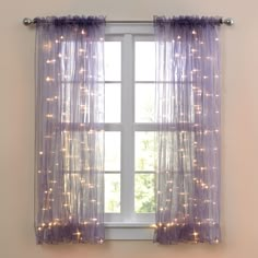 a window with purple curtains and lights on it