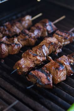 the meat is being grilled on the grill with skewered toothpicks