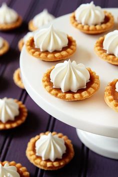 there are many small pies on the cake plate with white frosting and icing