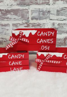 three red candy canes are on display in front of a brick wall with white fur