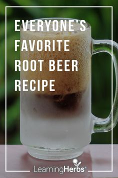 a glass mug filled with root beer sitting on top of a table