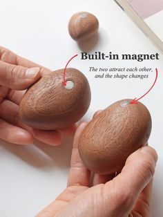 two wooden beads being held by someone's hand with the words built - in magnets