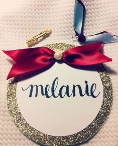 a round ornament with a red bow and name on it