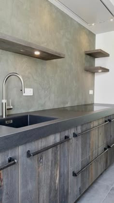 an industrial style kitchen with wooden cabinets and black counter tops, stainless steel faucet